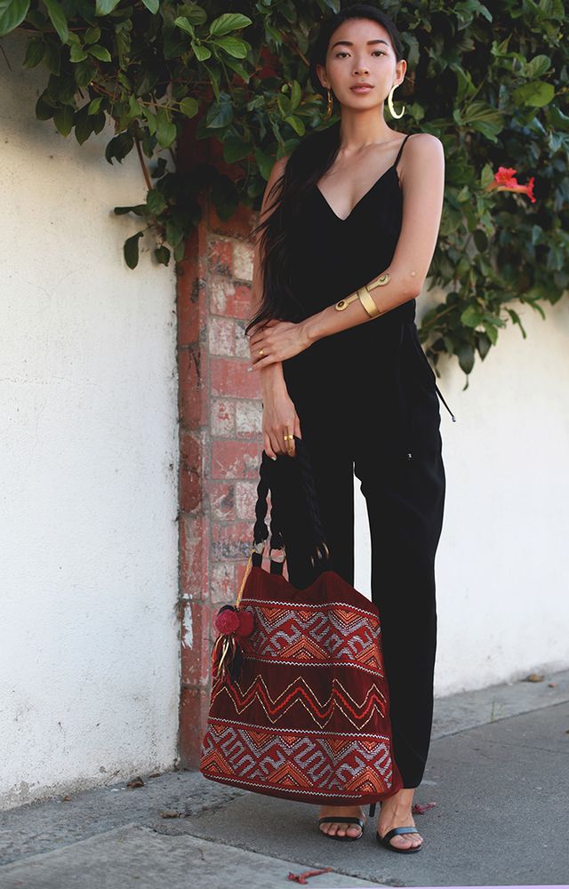 1468995245 2. gold cuffs and statement earrings with black jumpsuit and tribal bag