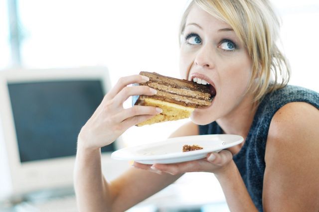 1470410294 close up of a woman eating a large piece of cake