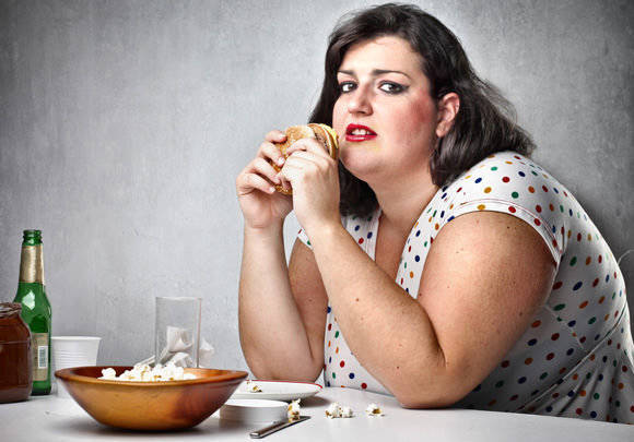 1444016634 obese woman eating junk food