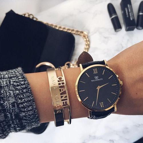 1503618041 15 a large black and gold watch and gold bracelets to highlight it
