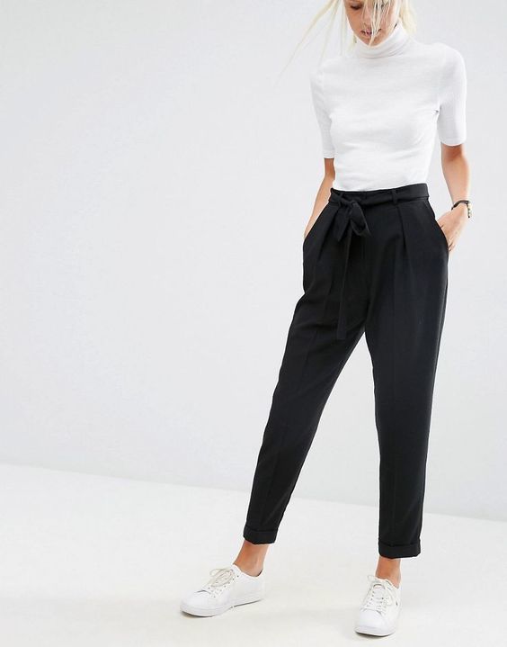 1523594951 03 black pants with pockets and a draped top a white top and sneakers for a business casual look