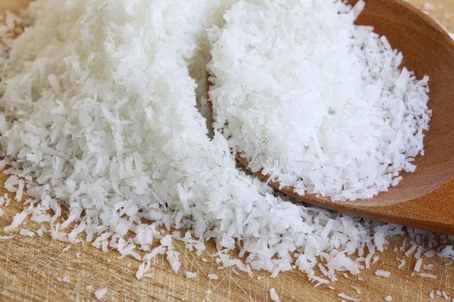 1530239852 fine desiccated coconut close up shot some wooden cutting board 67184478