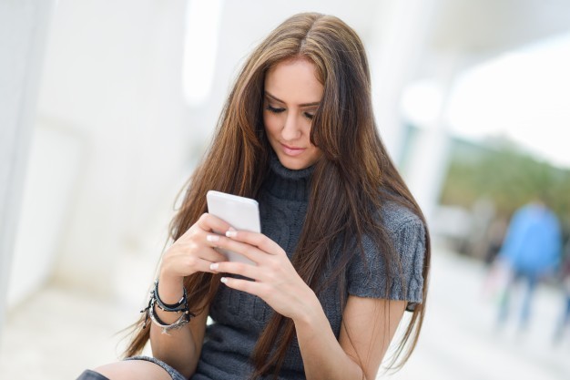 1530882455 long haired girl texting on her mobile phone 1139 171