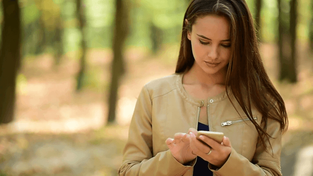1539503324 beautiful young woman reads message on the mobile phone girl with cell phone in the autumn park ebgumz6wax  f0000