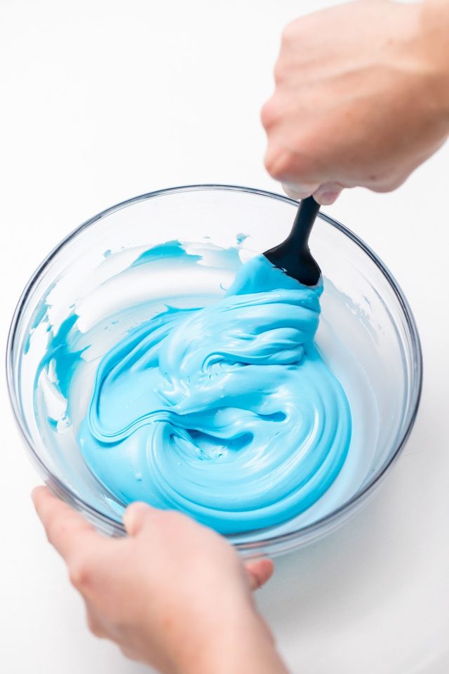 1549007905 5d4b2953 unicorn hot chocolate mixing blue food coloring with whipping cream in a mixing bowl 1200x1800