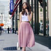 Icon 04 a white halter neckline crop top and a pink pleated midi skirt white heels and a bag