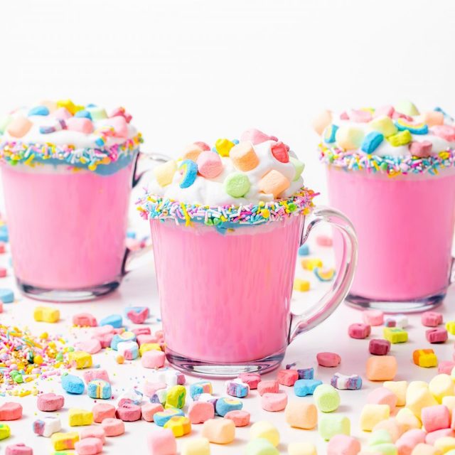 5d4b3097 unicorn hot chocolate pink hot chocolate with whipping cream lucky charms marshmellows on a white table 1400x933